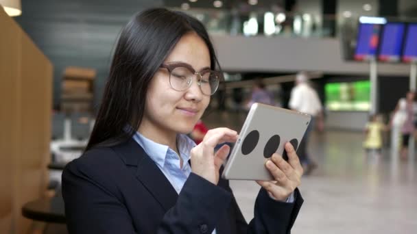 年轻快乐的亚洲女商人在机场大厅用平板电脑 — 图库视频影像