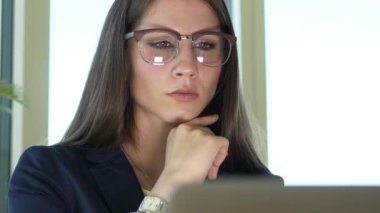 Güzel genç beyaz iş kadını dizüstü bilgisayar üzerinde çalışıyor