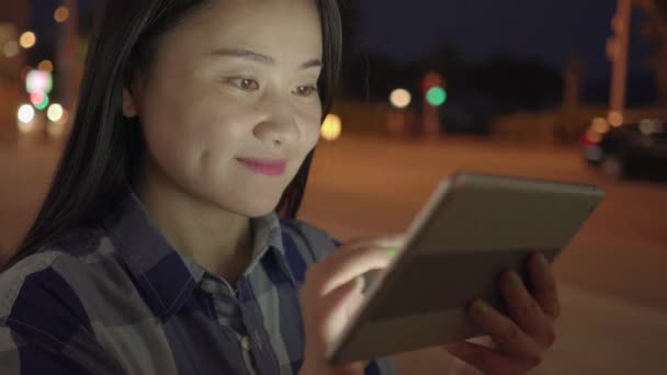 Νεαρή Ασιάτισσα Χρησιμοποιεί Τάμπλετ Νύχτα Κοντά Στο Δρόμο — Αρχείο Βίντεο