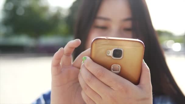 若いアジアの女性は 市内に立っている間に携帯電話を使用している — ストック動画