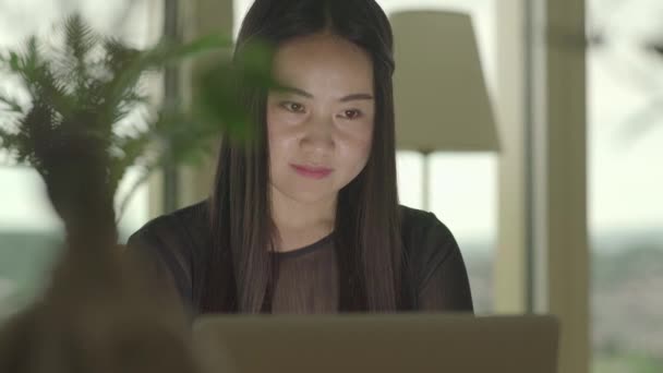 年轻的亚洲女人正在家里看笔记本电脑上的视频 — 图库视频影像