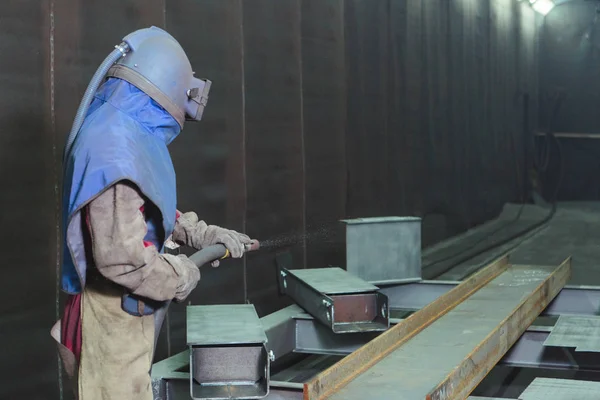 Sandstrahlen Metallstrahlen Ein Mitarbeiter Bereitet Ein Metallteil Zum Lackieren Vor lizenzfreie Stockfotos