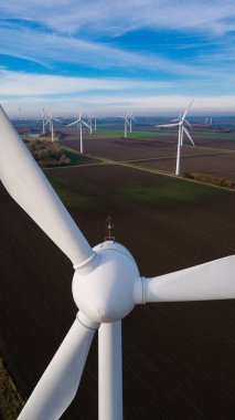 Wind turbine from aerial view. Close to the turbine. Sustainable development, environment friendly. Wind mills during bright summer day. Windmill. Agricultural fields on a summer day.