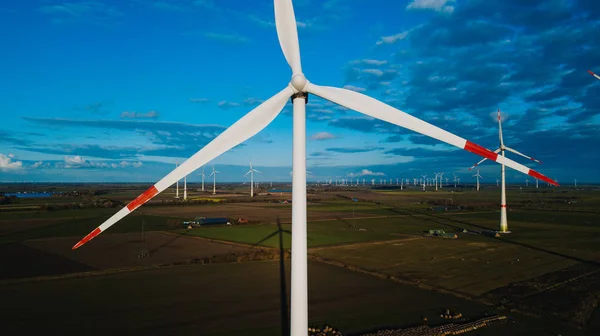 Türbin için kapatın. Rüzgar türbini havadan görünümden - sürdürülebilir kalkınma, çevre dostu. Rüzgar değirmenleri parlak yaz gün boyunca. Yel değirmeni. Bir yaz gününde tarım alanları.