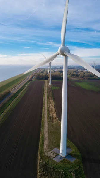 Wind turbine from aerial view. Close to the turbine. Sustainable development, environment friendly. Wind mills during bright summer day. Windmill. Agricultural fields on a summer day.