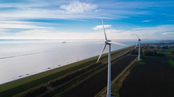 Wind turbine from aerial view. Close to the turbine. Sustainable development, environment friendly. Wind mills during bright summer day. Windmill. Agricultural fields on a summer day.