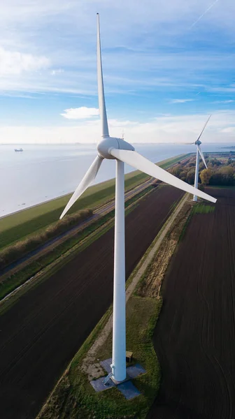 Wind turbine from aerial view. Close to the turbine. Sustainable development, environment friendly. Wind mills during bright summer day. Windmill. Agricultural fields on a summer day.