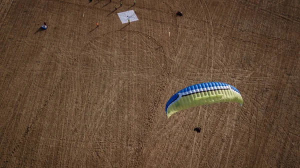 Le parapente survole les champs. En haute altitude. L'athlète tourne le courant thermique. Lève-toi. Météo pour les vols. Vue de dessus du parapente survolant un champ verdoyant avec une route. Satisfaction . — Photo