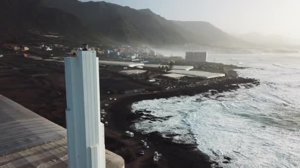 Punta del Hidalgo deniz feneri. Okyanusa bakan manzara. Gün batımı. Bu modern deniz feneri benzersiz bir açısal tasarıma sahiptir. Hava — Stok video