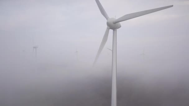 Windmolens in de mist bij zonsopgang. Wind turbine van lucht mening. Duurzame ontwikkeling — Stockvideo