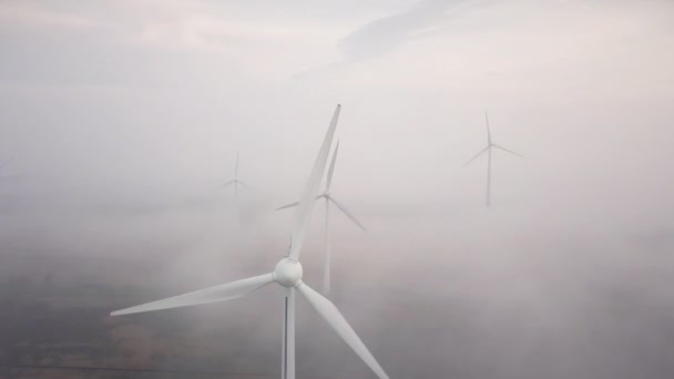 Windmolens in de mist bij zonsopgang. Wind turbine van lucht mening. Duurzame ontwikkeling — Stockvideo