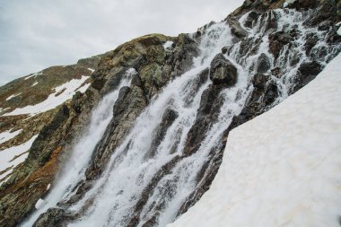 Dağdaki dağ şelalesi. Alps. Kar. Poster Resmi.