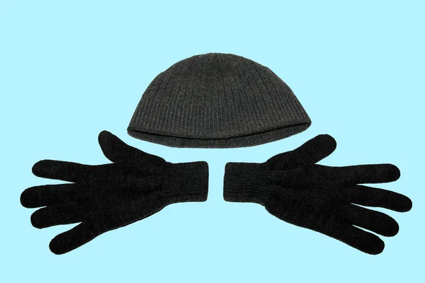 灰色の冬のニット手袋と灰色の冬の帽子のペア 青い背景に上からの眺め — ストック写真