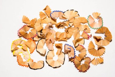 Beyaz bir kağıt üzerinde bir kalemden talaşı. Beyaz arka planda kalem talaşı. Yaratıcı karışıklık.