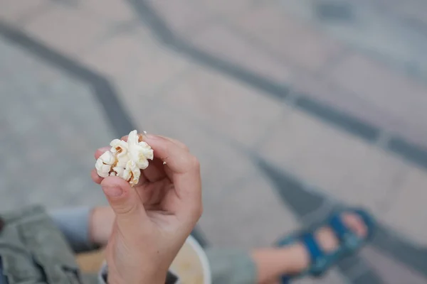 Little kid is holding popcorn with his fingers, top view — Stock Photo, Image