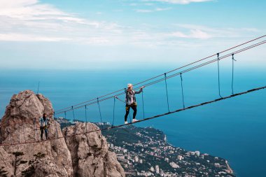 Genç kadını uçurum ip köprüde geçiş. AI-Petri, Crimea