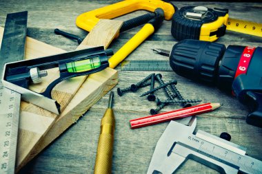 Araçlar ahşap yüzeyde, natürmort. Tornavida, kın, düzey, cetvel, kalem, vida, çekirdek