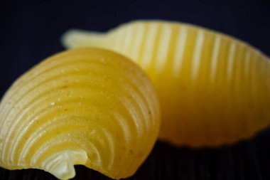 Salyangoz veya kabukları yakın siyah bir arka plan ile makarna