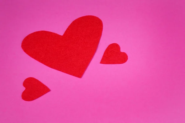 Red paper forms of  heart on a pink background