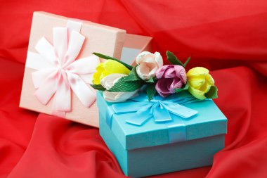 Kutlama, kadın gün veya doğum günü için kırmızı zemin üzerine kağıt çiçeklerle kutularındaki sunar