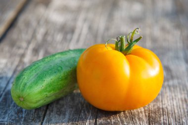 Tahta masanın üzerindeki salatalık ve domates