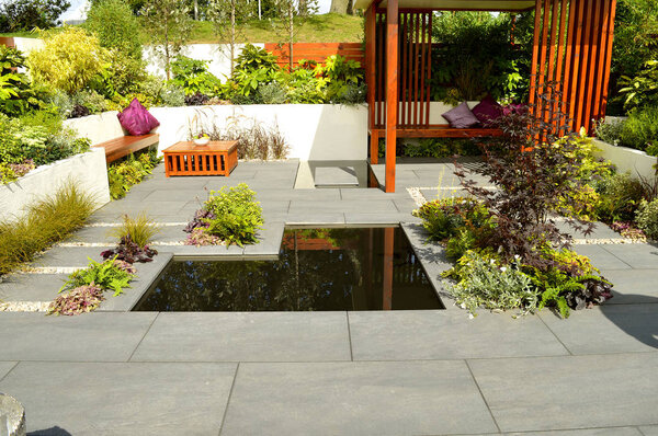 Low maintenance garden with a stone patio and ornamental garden pond