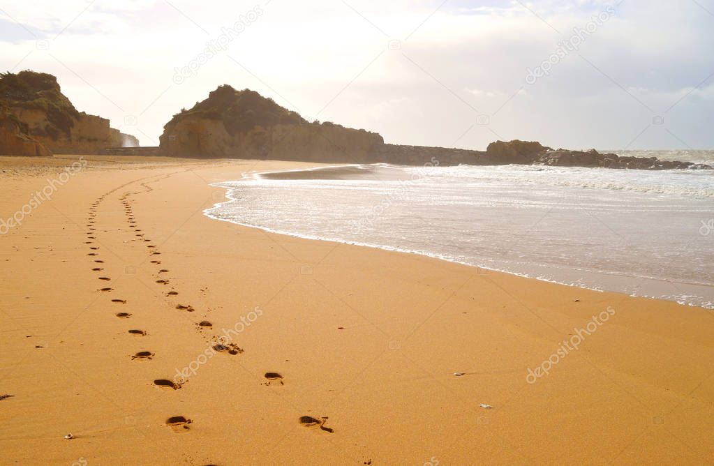 Footprints in the sand on Albufeira beach on the Algarve coast of Portugal