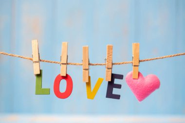 Kırmızı kalp şekli dekorasyon kopya alanı için mavi ahşap arka plan üzerinde metin satırıyla asılı. Düğün romantik ve Happy Valentine s gün tatil kavramı seviyorum