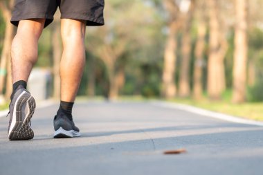 Genç fitness adam bacaklar açık Park'ta yürüyordunuz. yolun dışında çalışan erkek atlet. Asya atlet koşu ve patika güneş ışığı sabah egzersiz. Spor sağlıklı ve sağlık kavramları