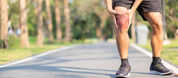 年轻的健身男子抱着他的运动腿受伤 训练时肌肉疼痛 亚洲跑步者在早上跑步和锻炼后膝盖疼痛和有问题 体育和健康的概念 — 图库照片