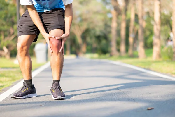 年轻的健身男子抱着他的运动腿受伤 训练时肌肉疼痛 亚洲跑步者在早上跑步和锻炼后膝盖疼痛和有问题 体育和健康的概念 — 图库照片