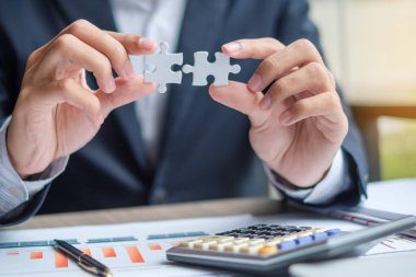 İşadamı el bağlantı çift parça, kalem, dizüstü bilgisayar, hesap makinesi ve evrak bulmaca. İş çözümleri, hedef, başarılı, hedef ve strateji kavramları