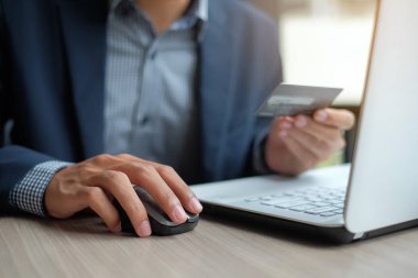 Kredi kartı tutan ve siparişleri Internet üzerinden yaparken online alışveriş için dizüstü bilgisayar kullanarak bir işadamı. iş, teknoloji, e-ticaret ve online ödeme kavramı