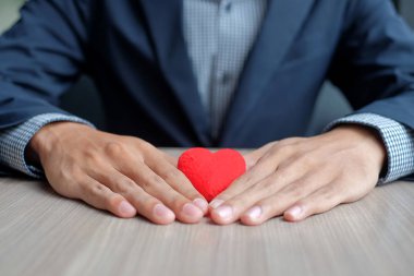 Kırmızı kalp tutan işadamı el