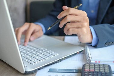 İşadamı dizüstü kullanarak analiz pazarlama planı için mali rapor ve grafik grafik Yöneticisi'ni hesaplamak. İş, finans ve muhasebe kavramları