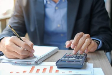 Analiz pazarlama planı için hesap makinesini kullanarak işadamı mali rapor ve grafik grafik Yöneticisi'ni hesaplamak. İş, finans ve muhasebe kavramları