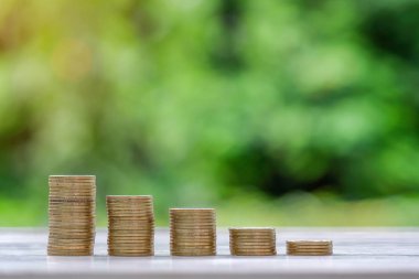 sabah güneş ışığı altında ahşap masa altın sikke yığını. İşletme, yatırım, emeklilik, finans ve para tasarrufu için gelecek kavramlar