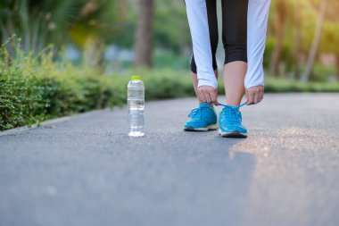 Genç fitness kadın bacaklar güneş ışığı sabah yolun dışında Asya atlet koşu ve egzersiz patika üzerinde çalışan park açık, kadın Çalıştırıcısı'nda yürüyüş. Spor, sağlıklı ve sağlık kavramları
