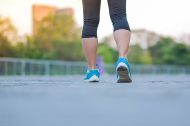 Genç fitness kadın bacaklar güneş ışığı sabah yolun dışında Asya atlet koşu ve egzersiz patika üzerinde çalışan park açık, kadın Çalıştırıcısı'nda yürüyüş. Spor, sağlıklı ve sağlık kavramları