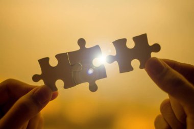 Siluet kadın el çift bağlama gündoğumu etkisi, jigsaw günbatımı arka plan ile tutarak işkadını karşı parça puzzle. İş çözümleri, hedef, başarı, hedefleri ve strateji kavramları