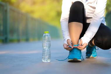 Genç fitness kadın bacaklar güneş ışığı sabah yolun dışında Asya atlet koşu ve egzersiz patika üzerinde çalışan park açık, kadın Çalıştırıcısı'nda yürüyüş. Spor, sağlıklı ve sağlık kavramları