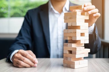 Yerleştirme veya ahşap blok kule çekerek işadamı el. İş planlama, Risk Yönetimi, çözüm ve strateji kavramları