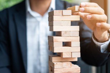 Yerleştirme veya ahşap blok kule çekerek işadamı el. İş planlama, Risk Yönetimi, çözüm ve strateji kavramları
