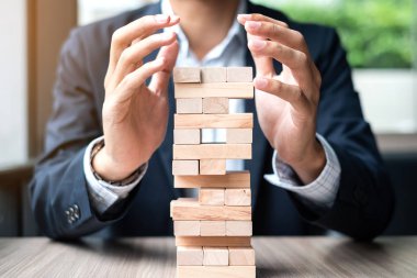 İşadamı el kule üzerinde ahşap blok kapak. İş planlama, Risk Yönetimi, çözüm ve strateji kavramları