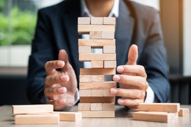 Yerleştirme veya ahşap blok kule çekerek işadamı el. İş planlama, Risk Yönetimi, çözüm ve strateji kavramları