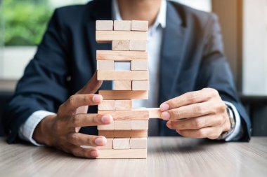 Yerleştirme veya ahşap blok kule çekerek işadamı el. İş planlama, Risk Yönetimi, çözüm ve strateji kavramları
