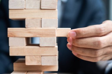 Yerleştirme veya ahşap blok kule çekerek işadamı el. İş planlama, Risk Yönetimi, çözüm ve strateji kavramları