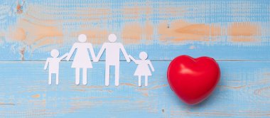 Aile kağıt mavi pastel renk ahşap arka plan üzerinde kırmızı kalp şekli. Sağlık ve sigorta kavramı