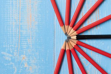 Siyah kalem ve mavi ahşap arka plan üzerinde kırmızı kalem. Strateji, liderlik, bağımsızlık, takım çalışması ve iş başarı kavramı. üstten görünüm ve kopya alanı