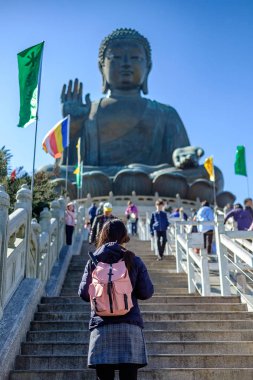 Genç kadın seyahat backpacker, Asya seyahat ziyaret Tian Tan veya Big Buddha Ngong Ping Lantau Island Po Lin manastırda bulunan. işareti ve popüler turistik Hong Kong için